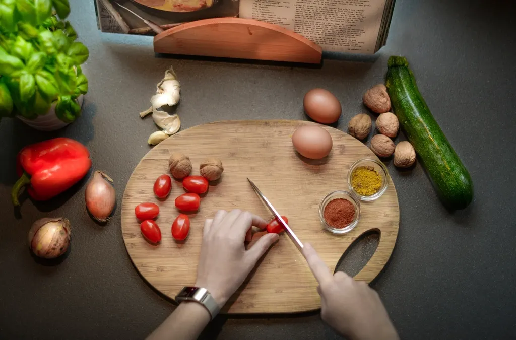 Persoa cortando verduras para preparar unha comida